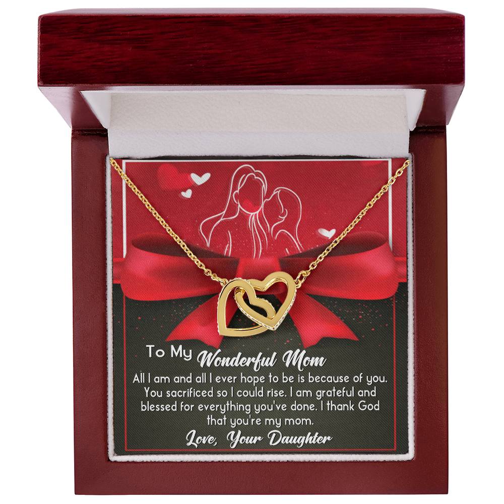 The "To Mom, Because Of You - Interlocking Hearts Necklace" comes in a gift box with a gold heart set with cubic zirconia crystals and includes a heartfelt message from daughter to mother on the inside cover.