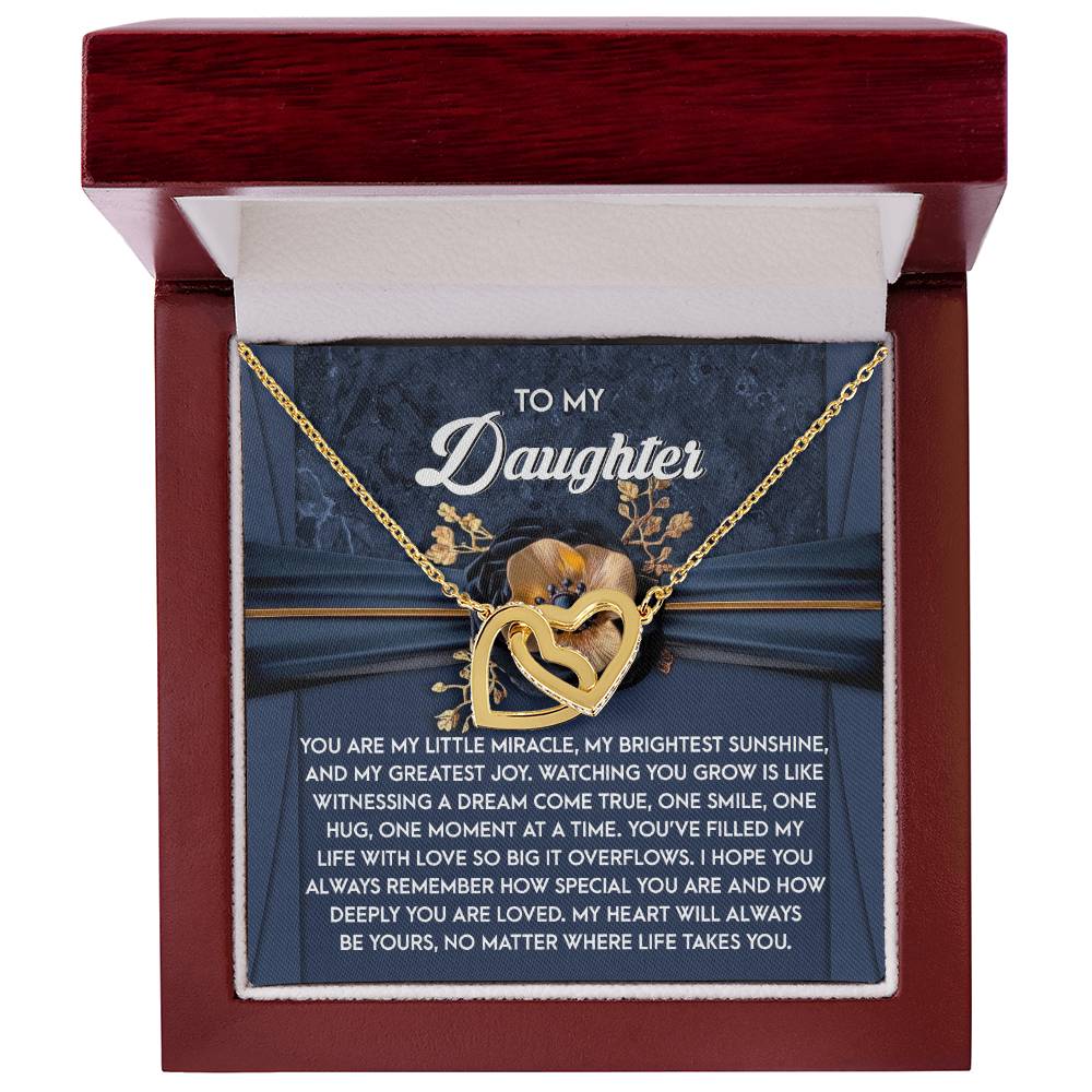 The Daughter-You Are Loved - Interlocking Hearts Necklace features a floral design, crafted from surgical steel with cubic zirconia crystals, nestled in a jewelry box. It includes a background card with the message "To My Daughter" and a sentimental note.