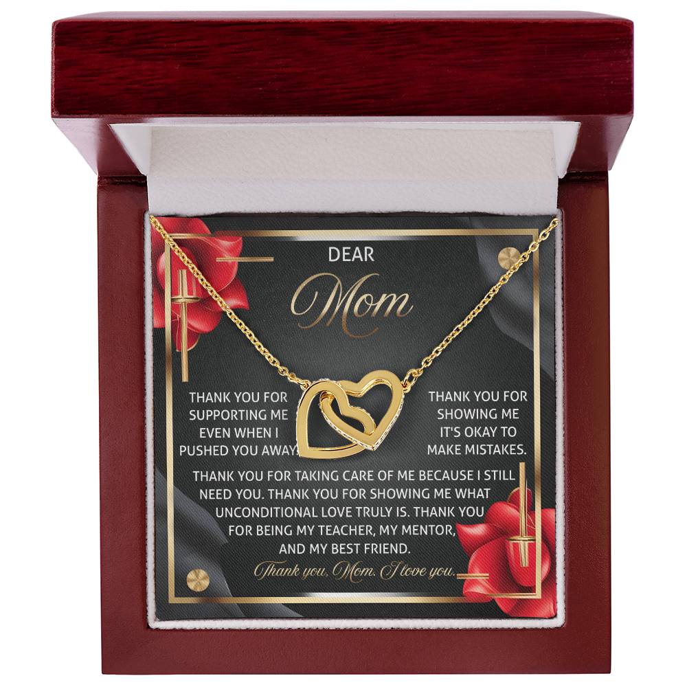 The Mom-Best Friend 2 - Interlocking Hearts Necklace sparkles in a rose gold finish, presented in a red velvet box with a background card featuring heartfelt gratitude to mom for her love and support, accented by red flowers at the corners.