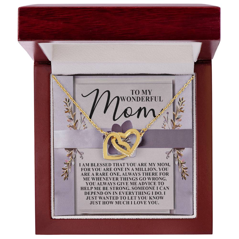 The Mom-Rare One - Interlocking Hearts Necklace, adorned with cubic zirconia crystals, comes in a wooden box. Inside is a heartfelt note expressing gratitude and love for a mother. A floral background enhances its elegance.