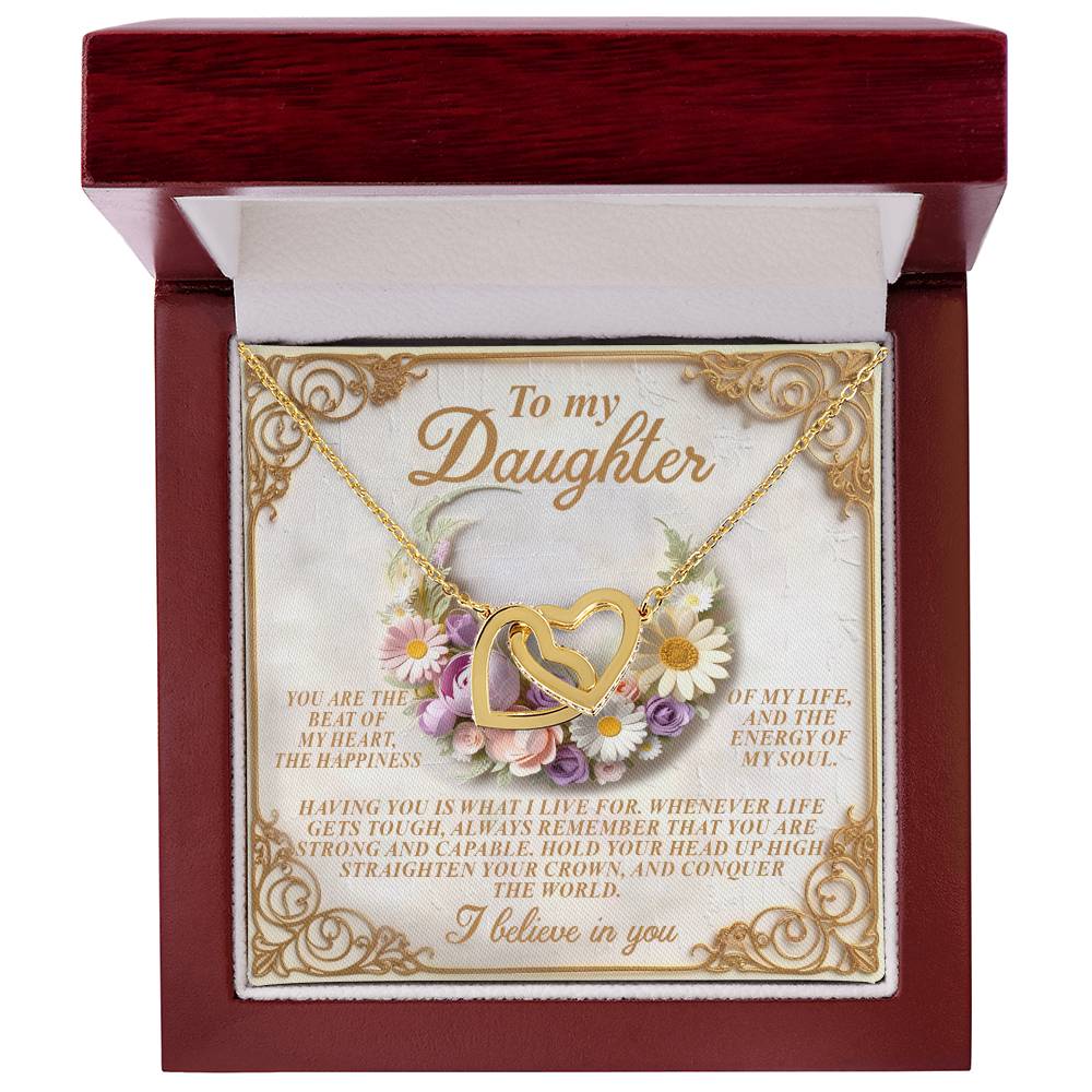 The Daughter-Heart Happiness necklace, featuring interlocking hearts adorned with cubic zirconia crystals, comes in a jewelry box with a "To my Daughter" message. The rose gold finish is elegantly highlighted by a floral and decorative frame background.
