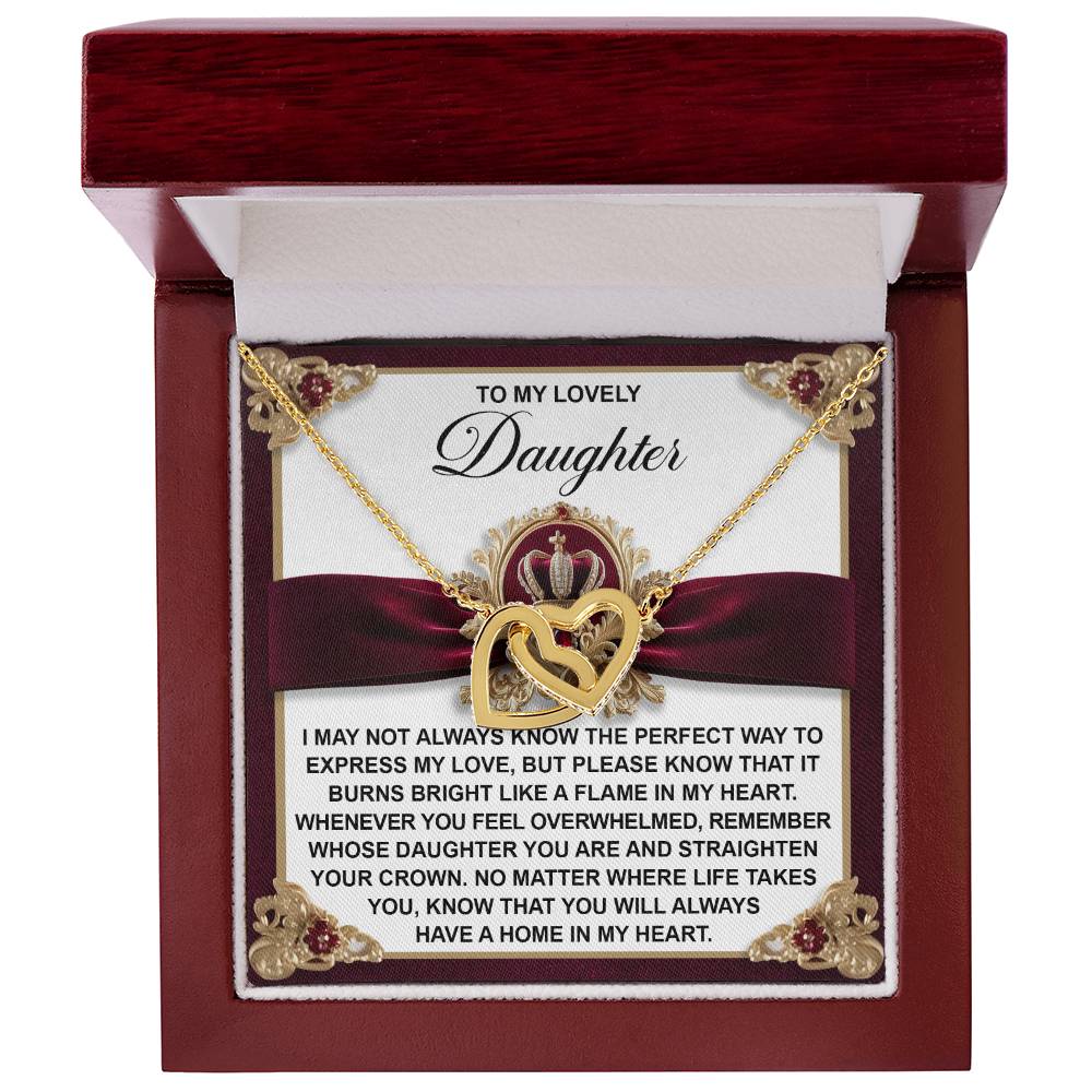 The Daughter-A Flame - Interlocking Hearts Necklace is a gold heart-shaped piece with cubic zirconia crystals, presented in a decorative box featuring a loving message for a daughter.