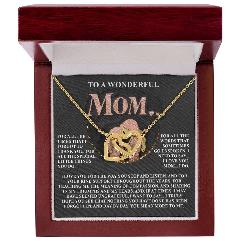 The Mom-More To Me 2 - Interlocking Hearts Necklace, adorned with cubic zirconia crystals, rests in a red jewelry box. Its lid conveys gratitude and love for Mom's unwavering support and guidance through the years.