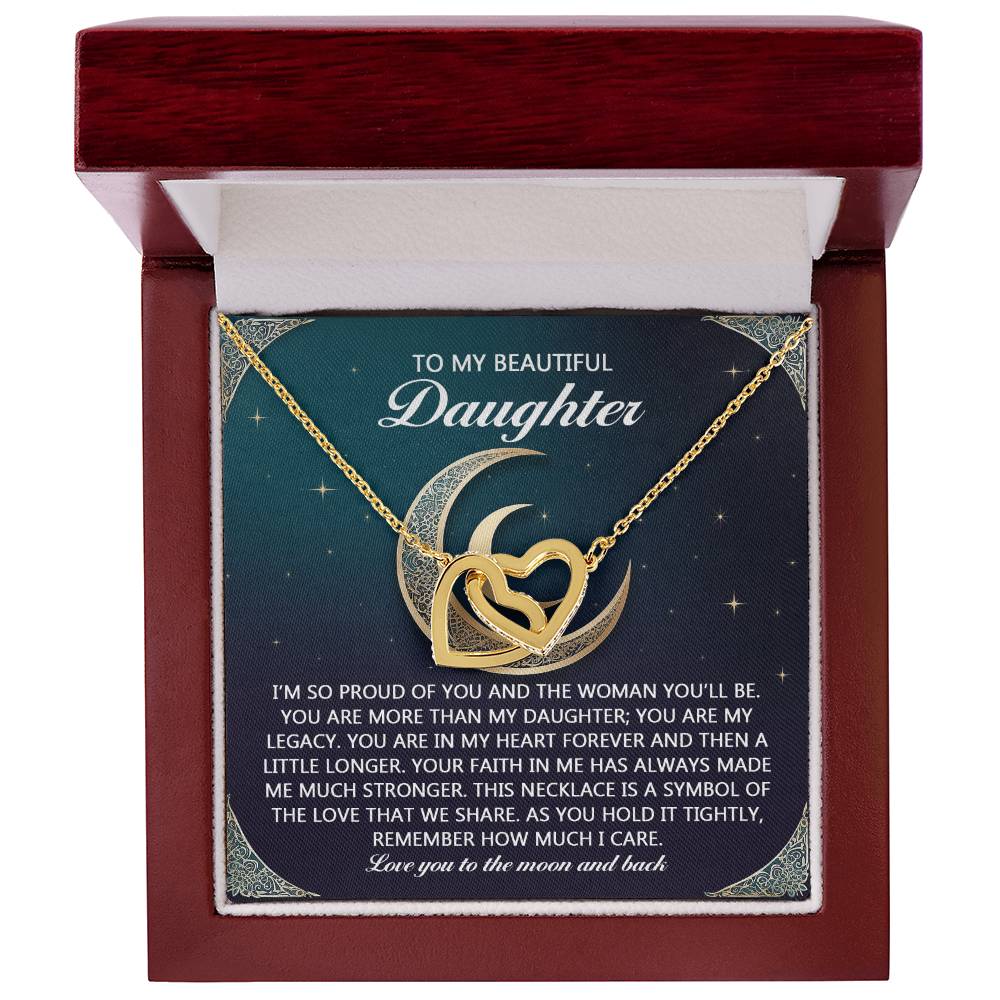 The "Daughter-Hold It Tightly" Interlocking Hearts necklace showcases cubic zirconia crystals and a rose gold finish with a crescent moon and heart design. Nestled in a red jewelry box, it bears an inscription expressing pride, love, and connection.