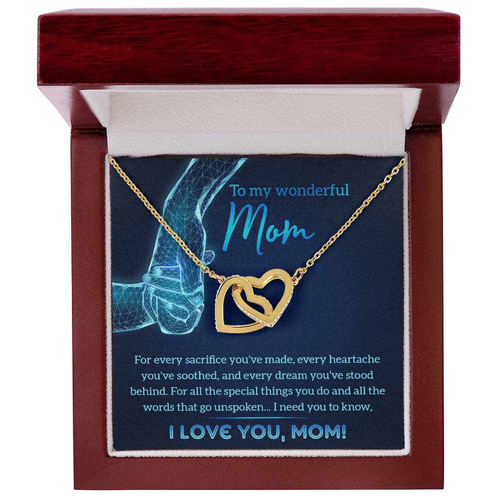 The "To Mom, Stood Behind - Interlocking Hearts Necklace," adorned with cubic zirconia crystals, is showcased in an open red box with a heartfelt message for a mother printed inside.