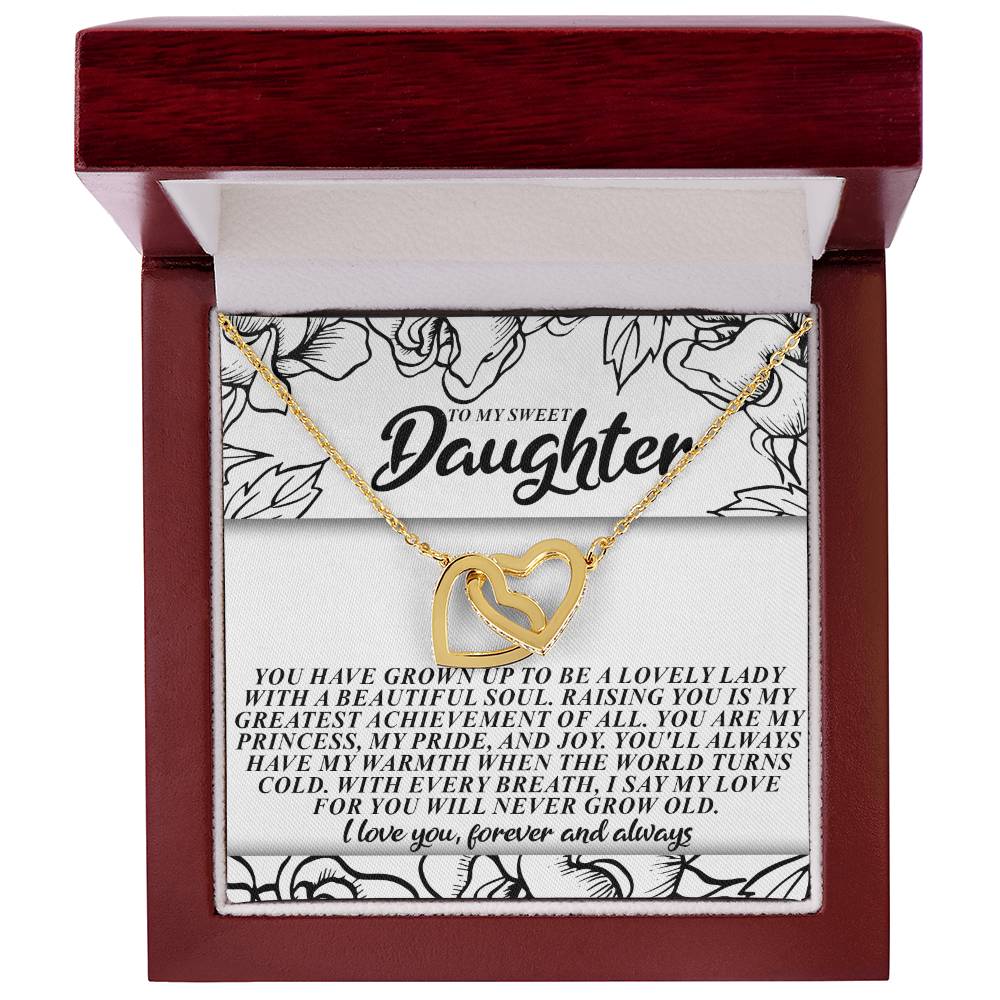 The Daughter-Beautiful Soul Interlocking Hearts Necklace, made of gold with cubic zirconia crystals, comes in a brown jewelry box. The lid says "To my sweet daughter," capturing love and pride in her growth and beauty through the sparkle of interlocking hearts.