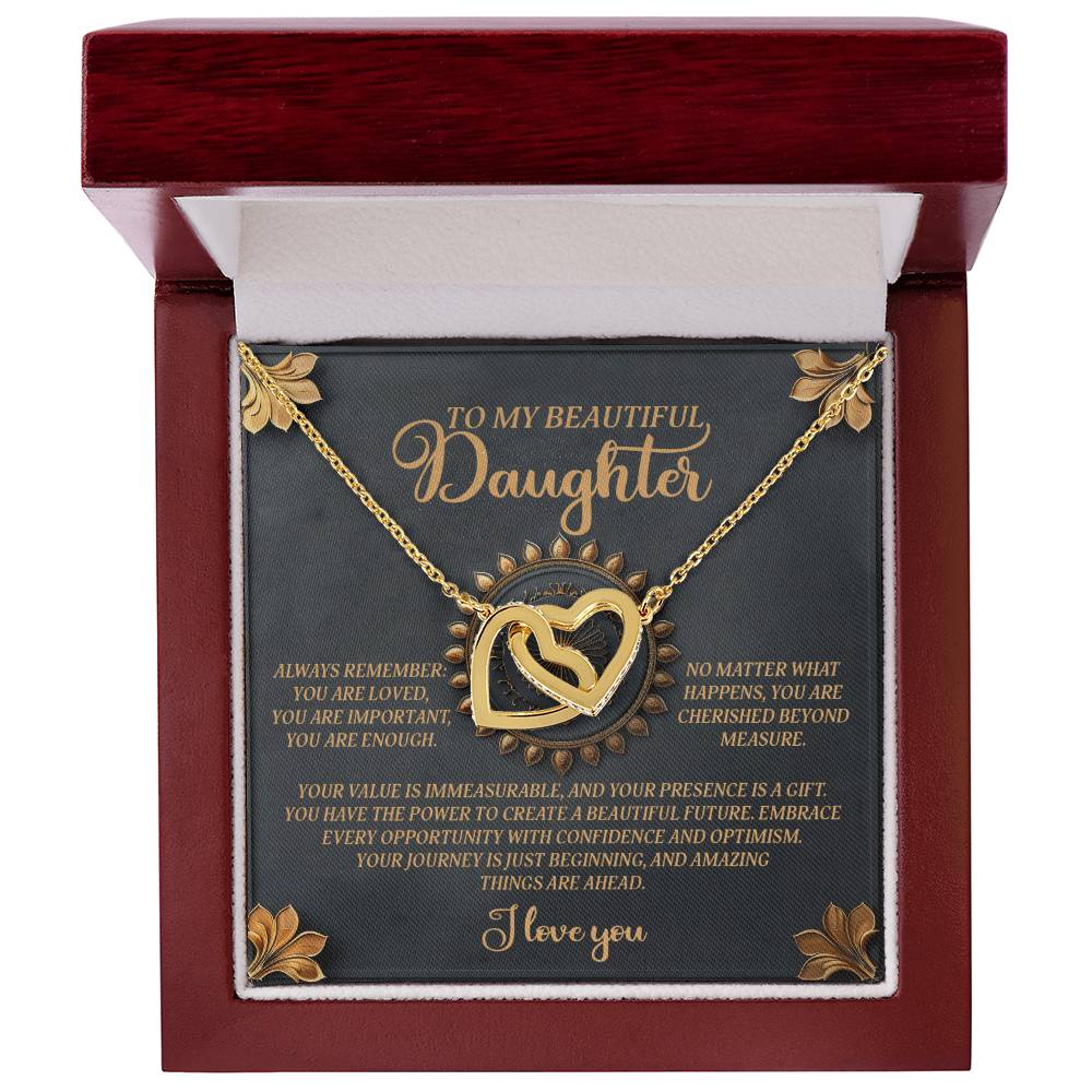 The Daughter-Beautiful Future - Interlocking Hearts Necklace is a gold piece in a wooden box, inscribed with "To my beautiful daughter," and contains an inspirational message about love and life's journey. It features rose gold finish and cubic zirconia crystals for added elegance.
