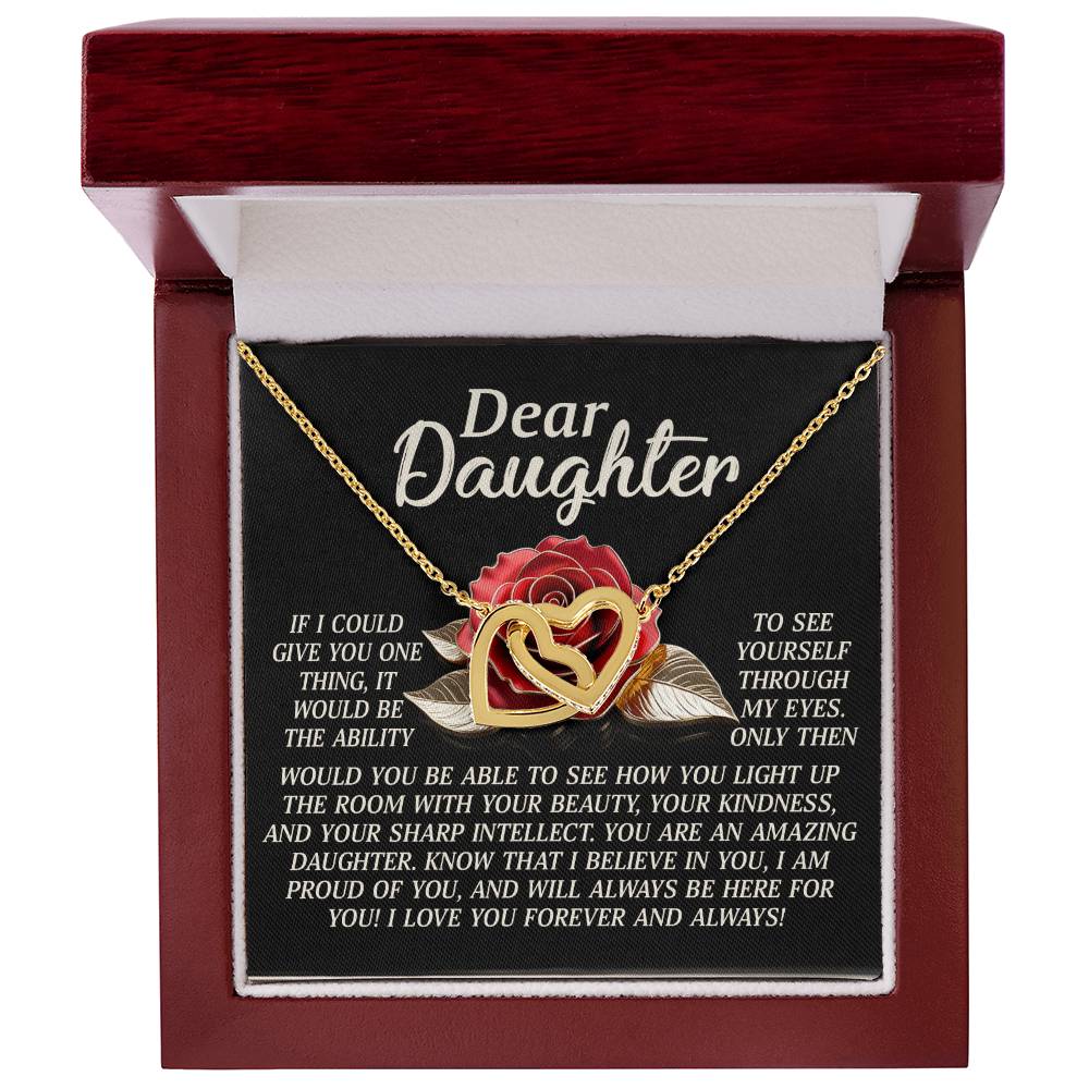 The "Daughter-Your Light - Interlocking Hearts Necklace" is a gold heart-shaped pendant with a rose gold finish and sparkling cubic zirconia, presented in a gift box featuring a heartfelt message and adorned with the elegance of a red rose.