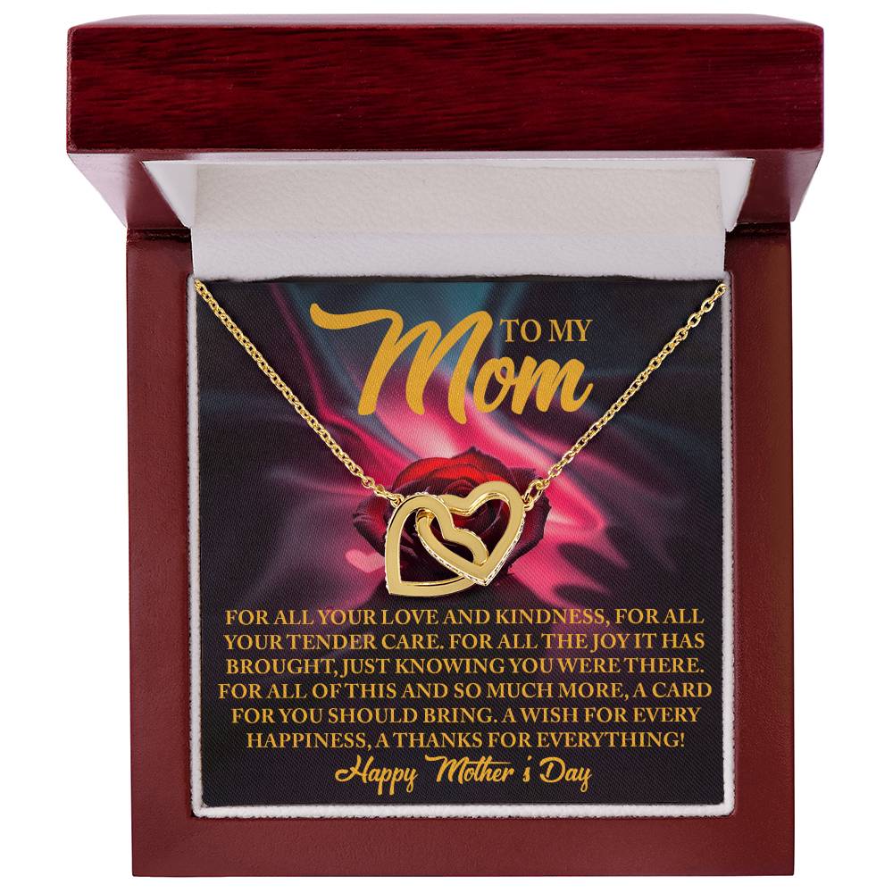 The Mom-Tender Care - Interlocking Hearts Necklace, beautifully adorned with cubic zirconia crystals, sits in a red jewelry box. A rose-decorated card behind it says "To my Mom," expressing gratitude and love for Mother's Day, wishing her endless joy and happiness.