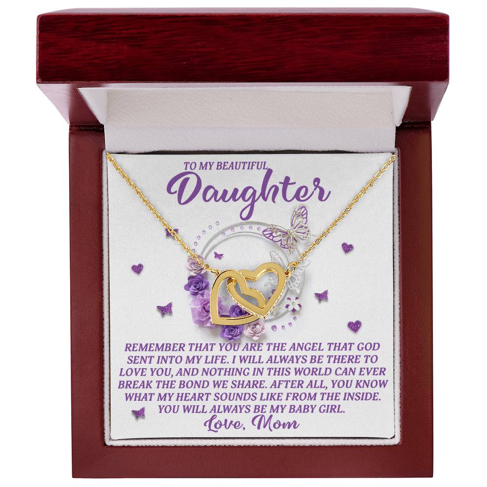 A jewelry box displays the Daughter-Angel Heart - Interlocking Hearts Necklace in rose gold, sparkling with cubic zirconia. The card says, "To my beautiful daughter... Love, Mom," against a backdrop of purple butterflies and floral accents.