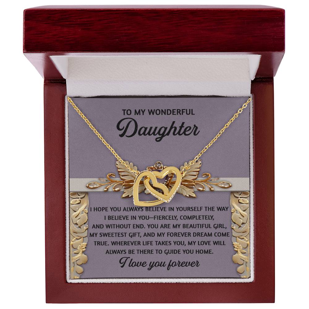 A rose gold Interlocking Hearts Necklace is displayed in an open, decorative wooden box. Inside the lid, a heartfelt message to a daughter conveys love and support. The necklace sparkles with cubic zirconia crystals against a soft backdrop.