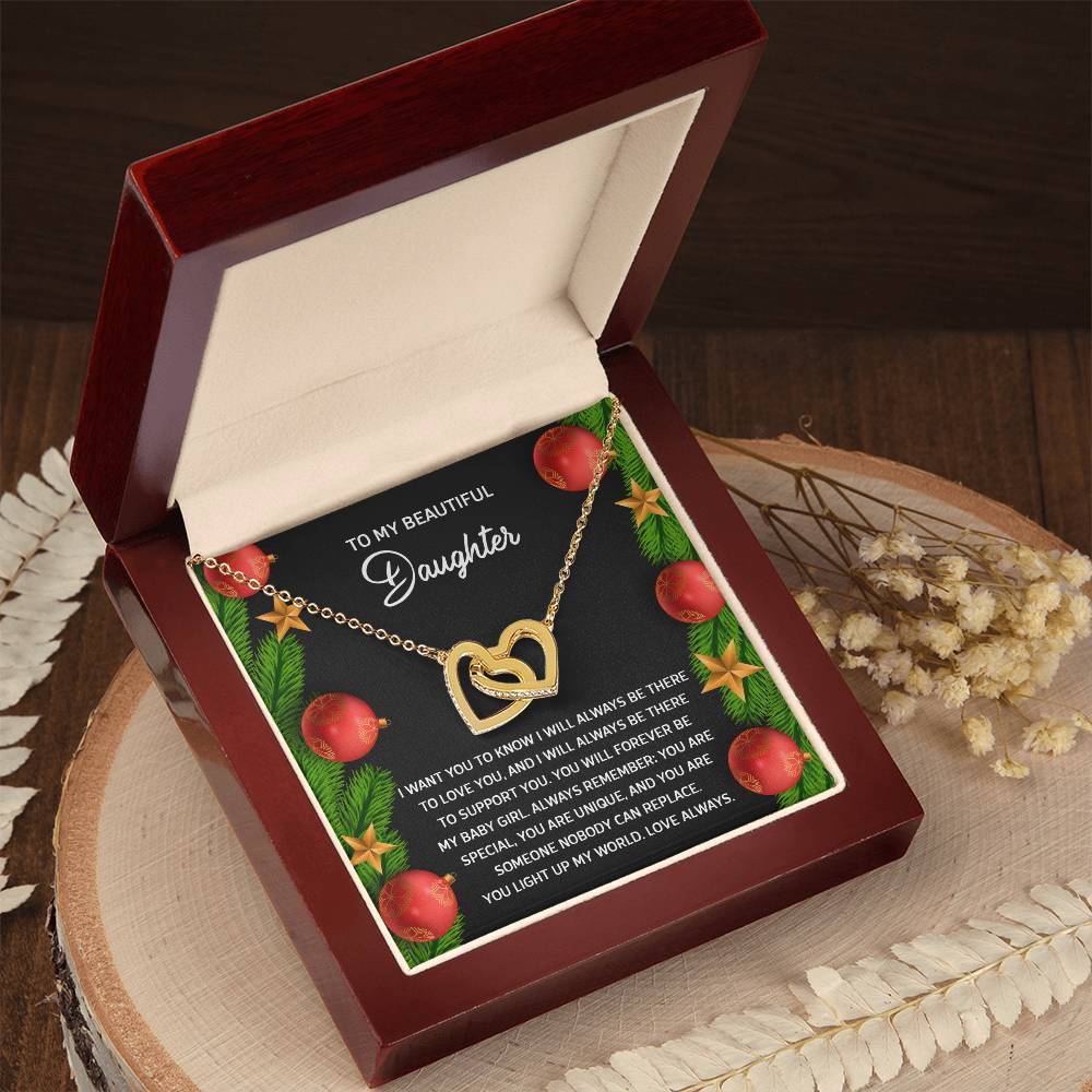 The Daughter-Nobody Can Replace - Interlocking Hearts Necklace, featuring a rose gold finish and brilliant cubic zirconia crystals, is elegantly presented in a wooden box. Set against a decorative background, it includes an affectionate message for your daughter.