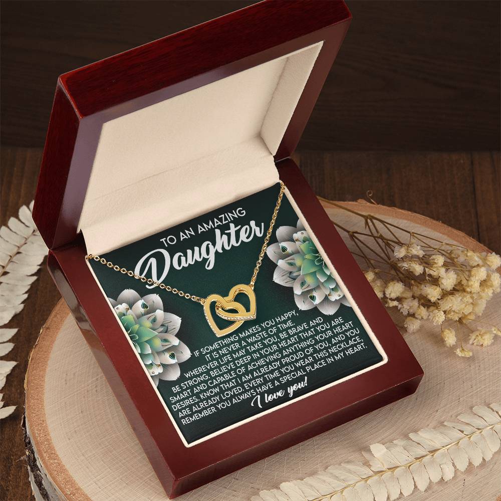 The Daughter-Special Place - Interlocking Hearts Necklace, featuring a rose gold finish and cubic zirconia, is displayed in an open red velvet box. It includes a heartfelt message with succulent illustrations for a daughter, accented by dried flowers and wooden decor.