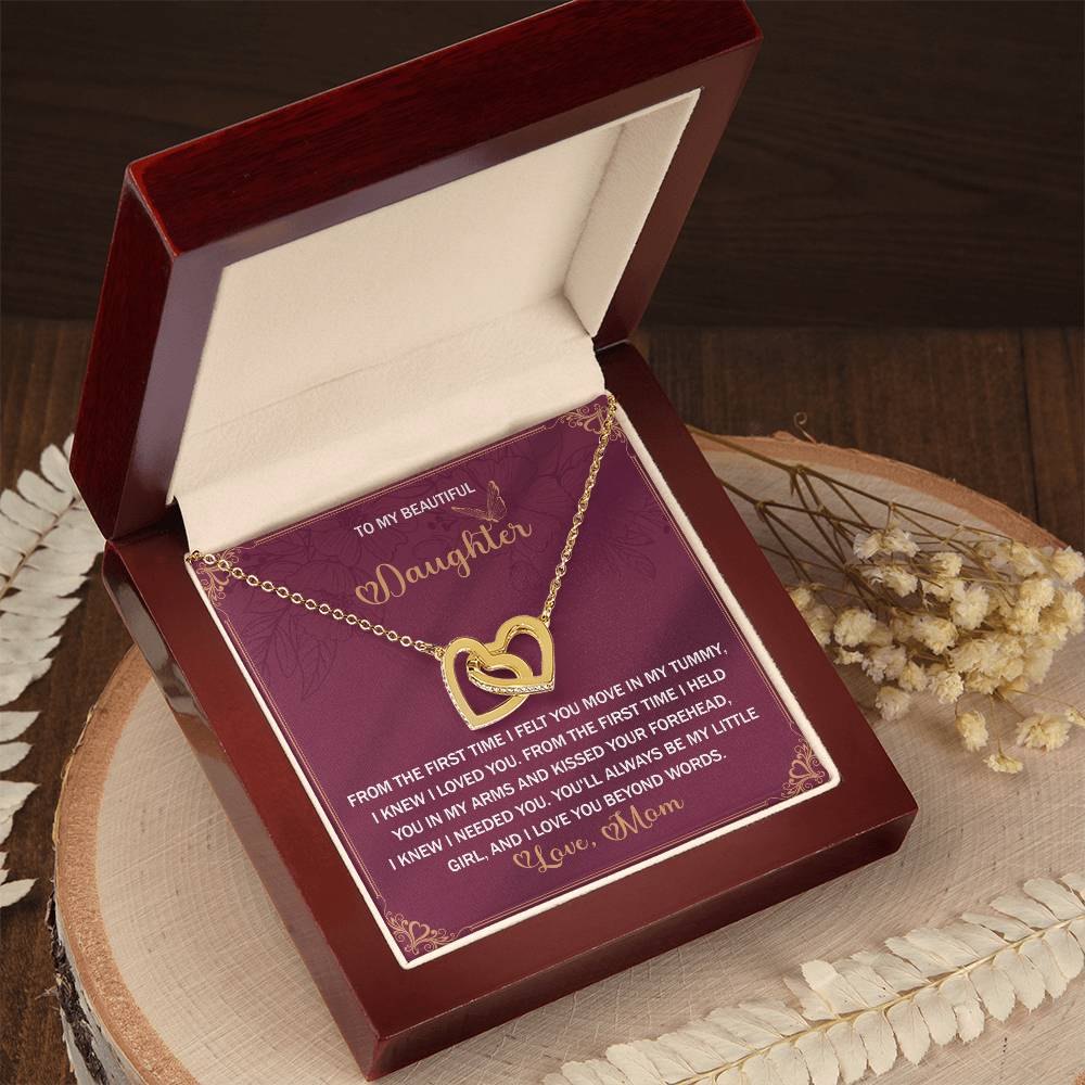 An open box reveals the "Daughter-Beyond Words - Interlocking Hearts Necklace," adorned with cubic zirconia crystals and a rose gold finish, paired with a heartfelt message from mother to daughter.