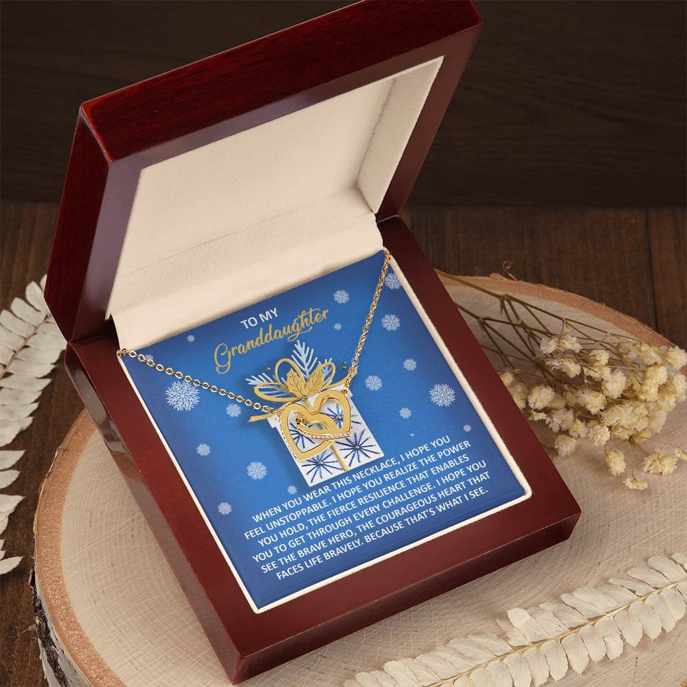 The Granddaughter-Brave Hero - Interlocking Hearts Necklace features a heart and deer design, elegantly presented in a wooden box and embellished with sparkling cubic zirconia crystals. Its rose gold finish adds a touch of sophistication, complemented by a heartfelt message card addressed to a granddaughter.