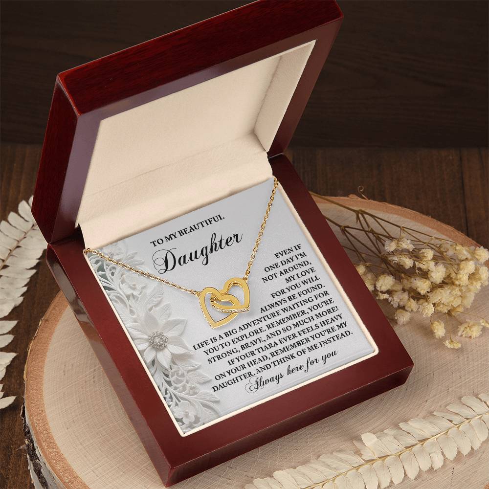 The Daughter-Think Of Me Interlocking Hearts Necklace is a heart-shaped gold necklace with a rose gold finish, nestled in a wooden box, inscribed with words of love for a daughter.