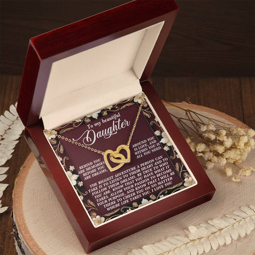 The jewelry box unveils the Daughter-Follow Dreams - Interlocking Hearts Necklace with cubic zirconia crystals. The lid has a loving, encouraging message for a daughter and is set on wood, with dried flowers around it.