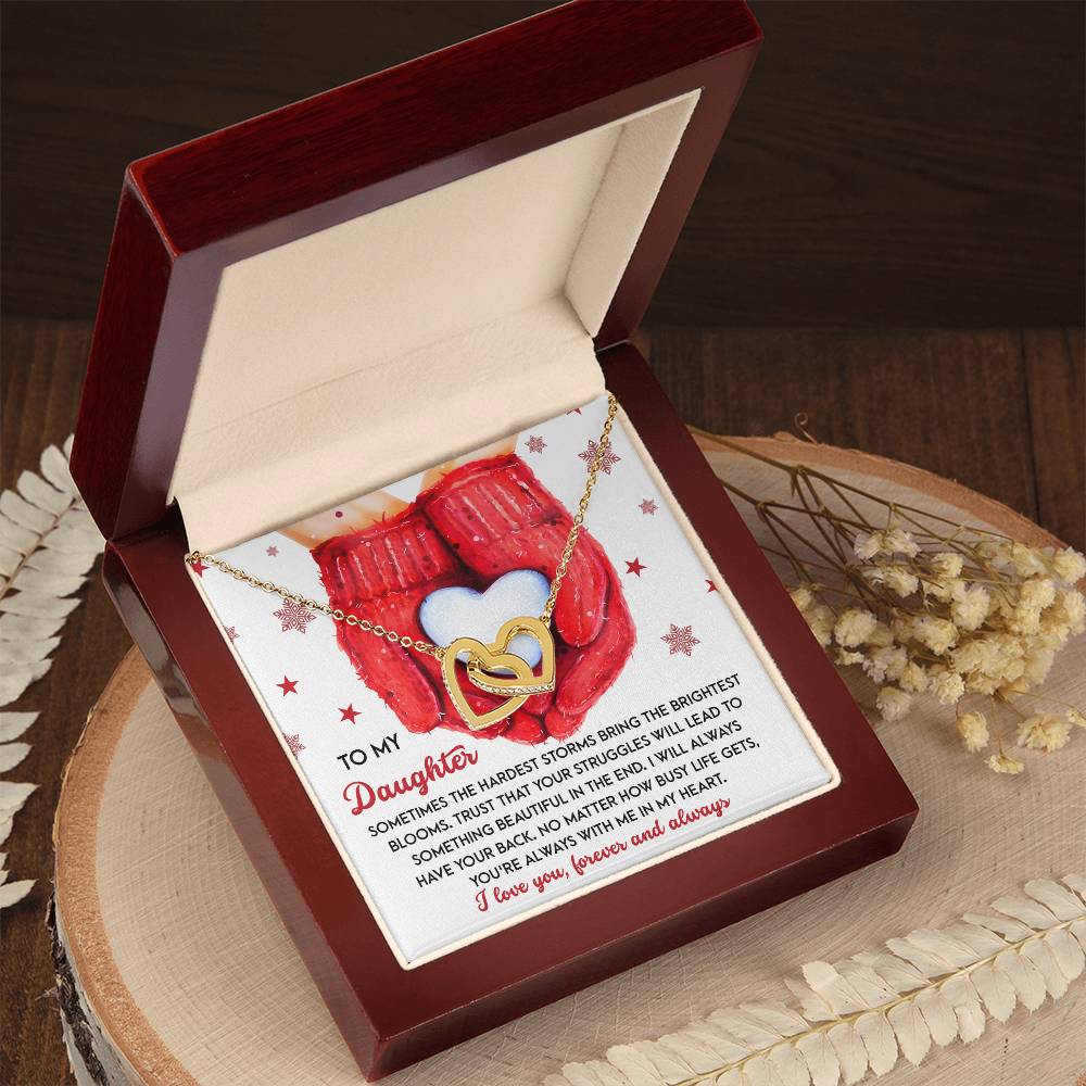 The Daughter-In My Heart - Interlocking Hearts Necklace, featuring a heart-shaped design with dazzling cubic zirconia crystals and a rose gold finish, comes in a wooden box and includes a heartfelt card message for your daughter.