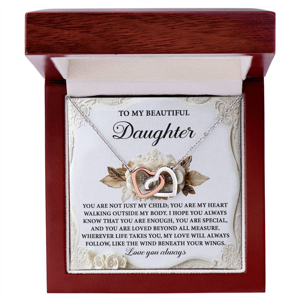 The Daughter-Beneath Your Wings Interlocking Hearts Necklace, adorned with cubic zirconia crystals, comes in a wooden box accompanied by a sentimental printed message for your daughter.