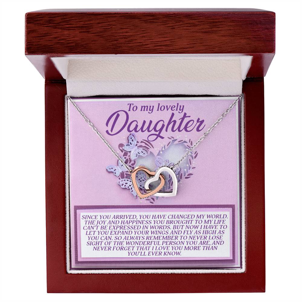 The Daughter-Expand Wings - Interlocking Hearts Necklace is embellished with cubic zirconia crystals and packaged in a gift box with a "To my lovely Daughter" card, conveying love and encouragement.