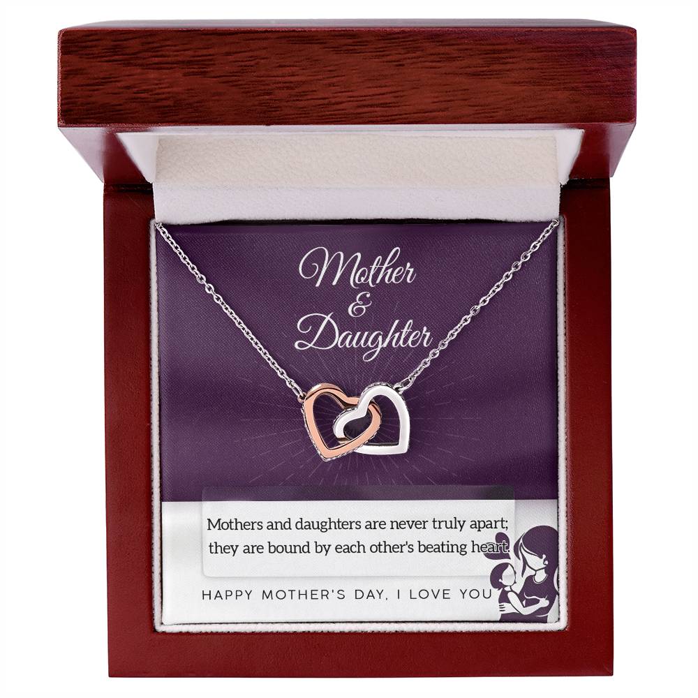 The Mother & Daughter-Never Truly Apart Interlocking Hearts Necklace in rose gold with cubic zirconia crystals comes in a wooden gift box. The insert reads "Mother & Daughter" and says: "Happy Mother's Day, I love you.