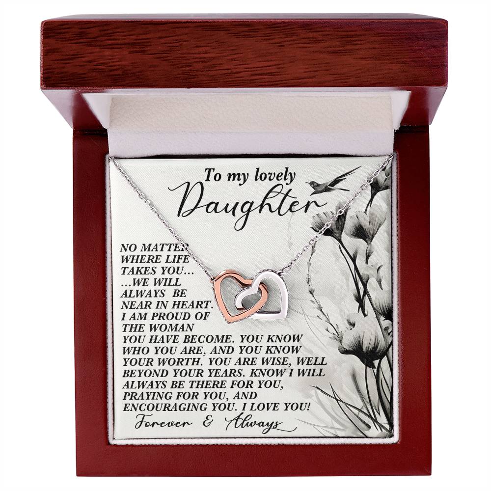 The Daughter-Heart Near - Interlocking Hearts Necklace features a rose gold finish, resting in a jewelry box with the lid inscribed: "To my lovely Daughter," and a loving message of pride and support. Sparkling cubic zirconia crystals enhance the box's elegant white interior.