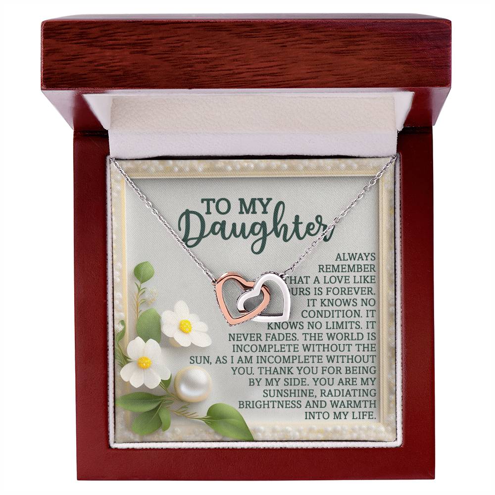 The Daughter-Love Forever Interlocking Hearts Necklace features two-tone hearts in a wooden box with a message: "To My Daughter. Always remember that love like ours is forever." Adorned with cubic zirconia, it symbolizes your radiant warmth and endless love.