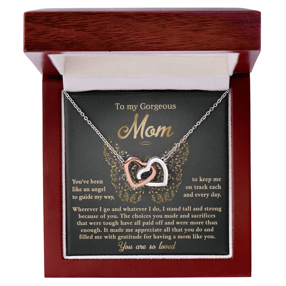 The "To Mom, Like An Angel - Interlocking Hearts Necklace," embellished with cubic zirconia, comes in a box with the lid that reads "To my Gorgeous Mom" and includes a heartfelt message, making it a cherished and unique gift.