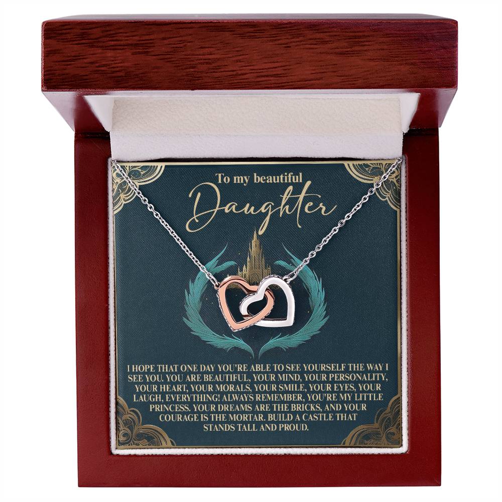 The Daughter-Little Princess Interlocking Hearts Necklace features silver and rose gold pendants with sparkling cubic zirconia. It comes in a wooden box with an inside lid carrying a heartfelt message to a daughter, expressing love, pride, and admiration.