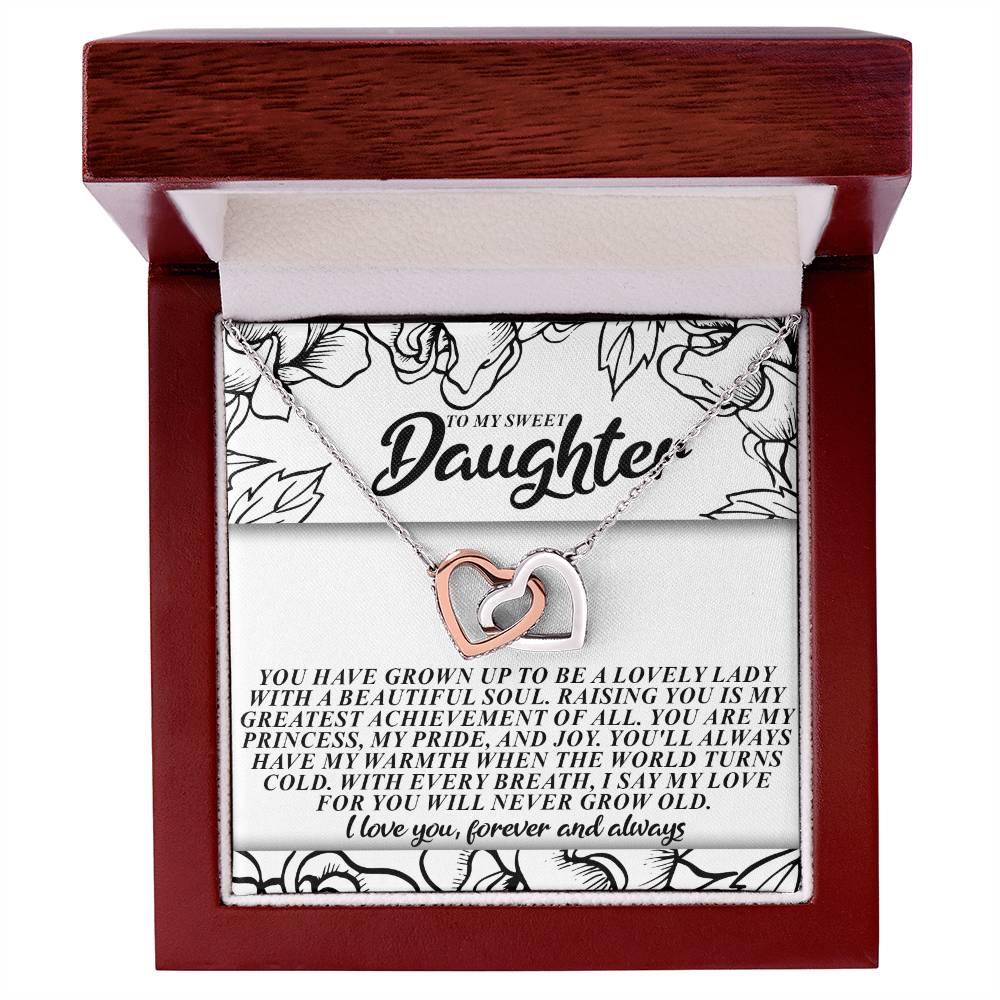 The Daughter-Beautiful Soul - Interlocking Hearts Necklace includes silver and rose gold pendants with cubic zirconia crystals in a gift box. It comes with a floral card expressing love and pride for a daughter.