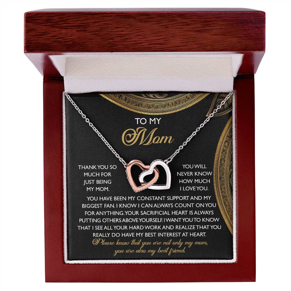 The Mom-Best Friend - Interlocking Hearts Necklace, featuring a rose gold finish and cubic zirconia crystals, is elegantly showcased in a wooden box. The message card reads "To my mom," conveying gratitude and love.