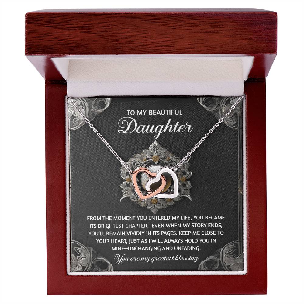 The Daughter-Greatest Blessing Interlocking Hearts Necklace, made of surgical steel with a rose gold finish, beautifully displays cubic zirconia crystals. It comes in a gift box with a heartfelt message to your daughter.