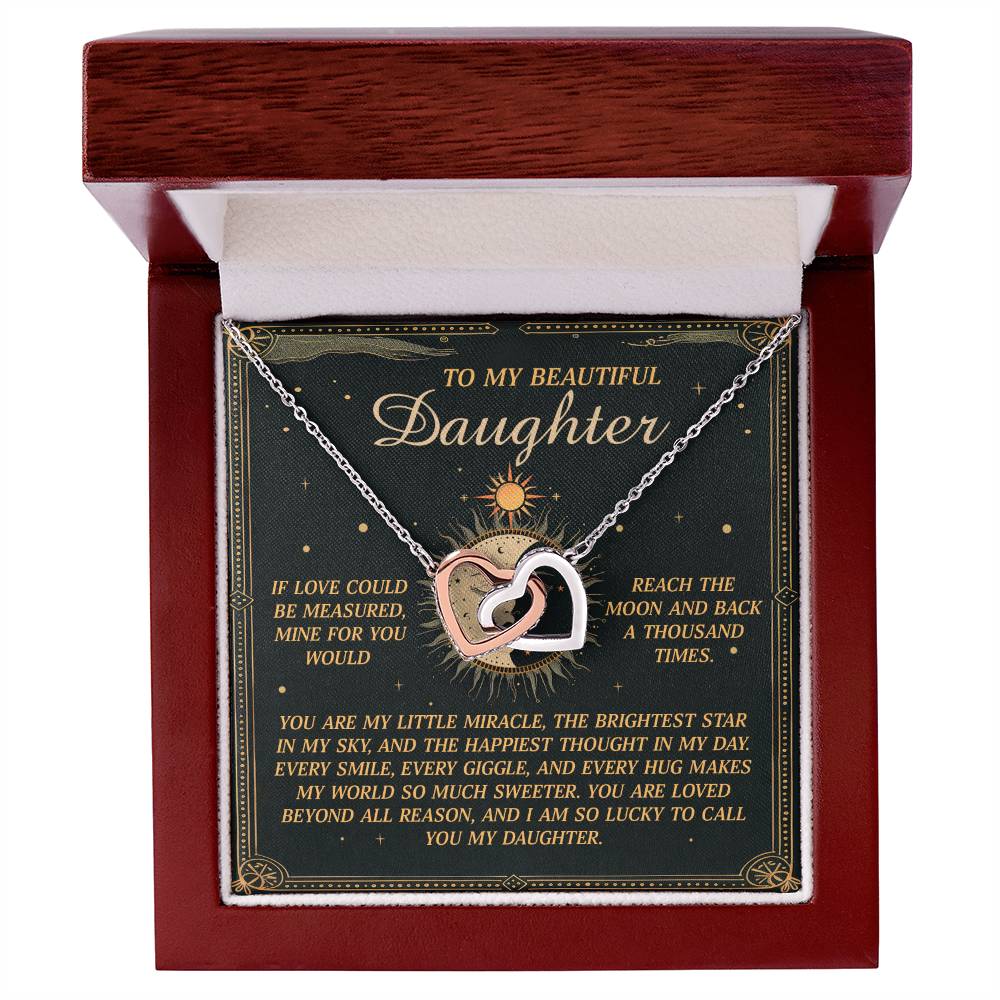 The Daughter-To Call You - Interlocking Hearts Necklace, adorned with cubic zirconia crystals and a rose gold finish, sits in an open box. A heartfelt message inside celebrates a daughter as a miracle and the brightest star, complemented by celestial designs for added elegance.