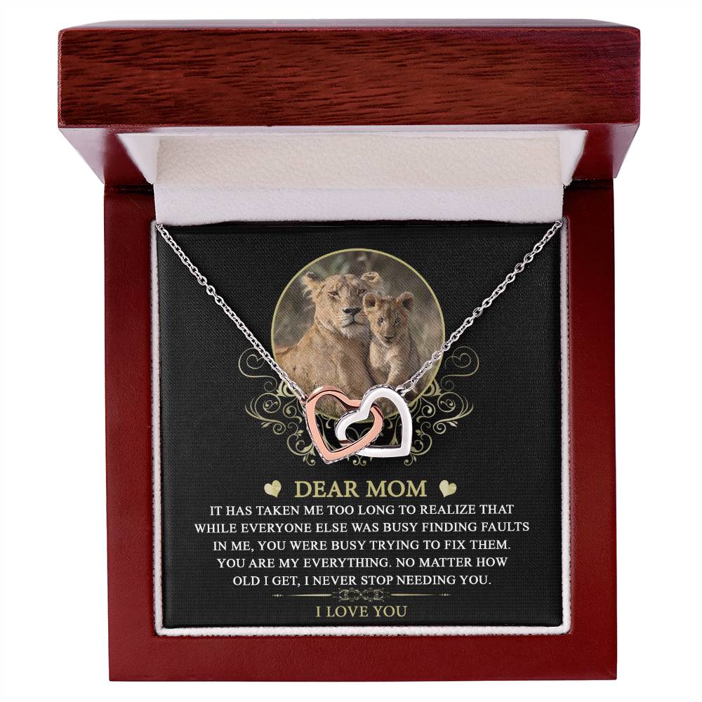 The "To Mom, My Everything - Interlocking Hearts Necklace," adorned with cubic zirconia crystals, comes in an elegant open box featuring a heartfelt message for a mother and an image of a lioness and cub, beautifully symbolizing the parent-child bond.