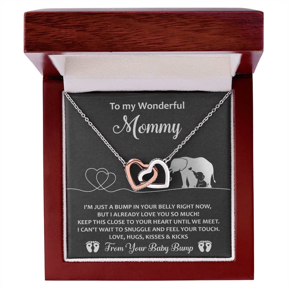 The "To Mama To Be, Until We Meet - Interlocking Hearts Necklace" is embellished with cubic zirconia crystals and presented in a wooden box. The message "To my Wonderful Mommy" includes a heartfelt note from an unborn baby, making it a unique gift of love and anticipation.