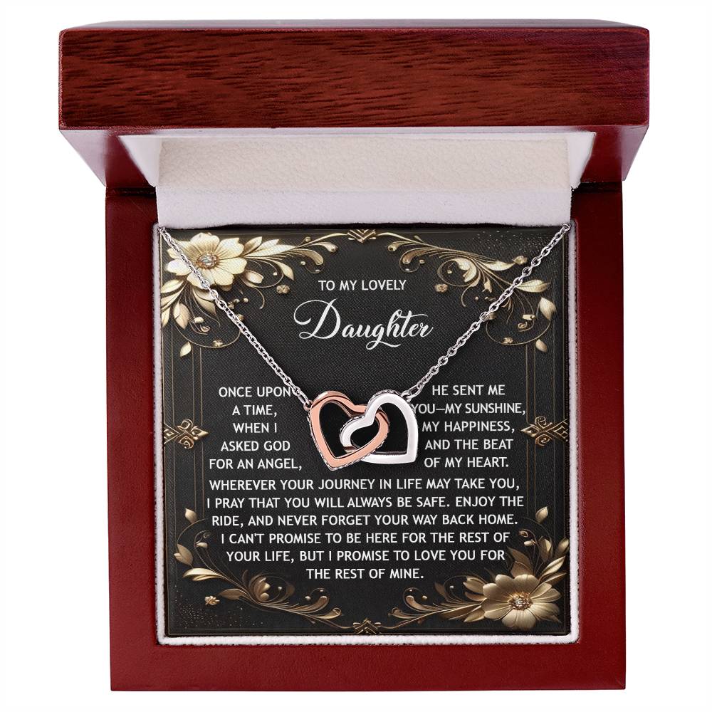 The "Daughter-Be Safe - Interlocking Hearts Necklace" features interlocking hearts adorned with cubic zirconia crystals, presented in a jewelry box with a sentimental message for a daughter.
