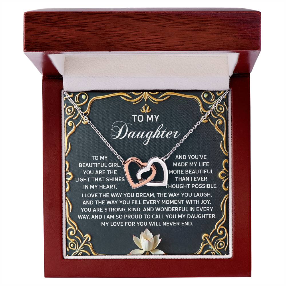 The Daughter-Never End Interlocking Hearts necklace features a rose gold finish with sparkling cubic zirconia crystals, nestled in a wooden box, and includes a heartfelt message for your daughter.