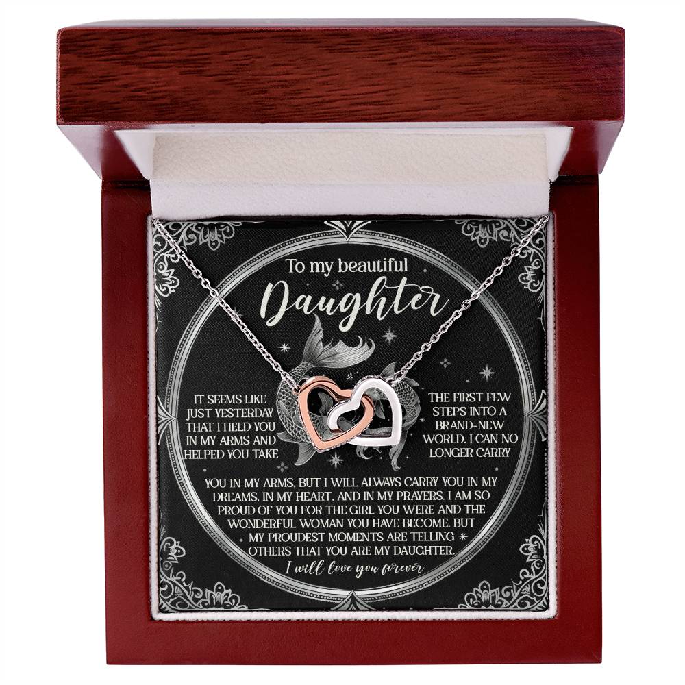 The Daughter-In My Prayers - Interlocking Hearts Necklace is showcased in an open wooden gift box, featuring silver and rose gold hearts with cubic zirconia crystals. The interior lid displays a heartfelt message for a daughter on a decorative card.