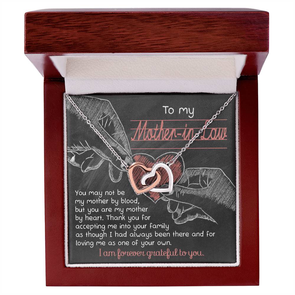 The "To Mother-In-Law, Mother By Heart - Interlocking Hearts Necklace," featuring cubic zirconia crystals, is presented in a wooden box with an elegant cursive message for a heartfelt gift.