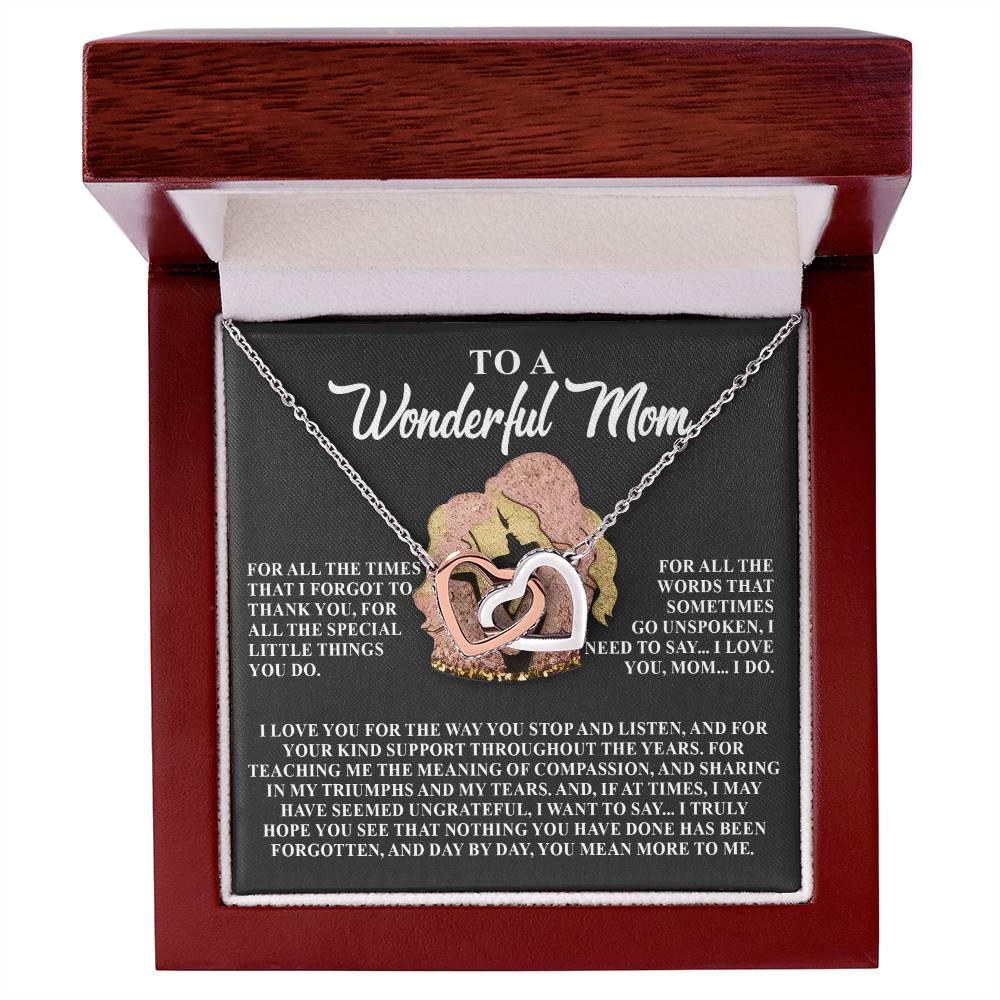 The Mom-More To Me Interlocking Hearts Necklace features a rose gold finish with cubic zirconia crystals in a wooden box. Inside, the message reads, "To a Wonderful Mom," with love and gratitude.