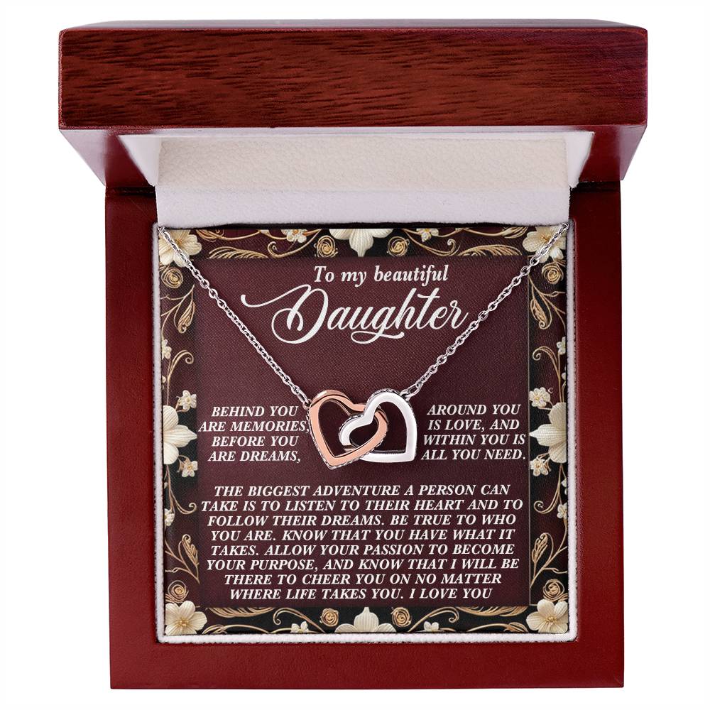 The Daughter-Follow Dreams Interlocking Hearts Necklace features a rose gold finish and comes in a wooden jewelry box. The lid reads, "To my beautiful Daughter," with a heartfelt message inside surrounded by floral accents, while cubic zirconia crystals add sparkle.