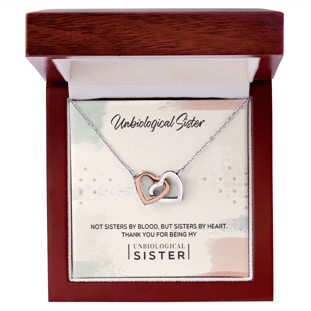 Silver necklace with To My Unbiological Sister, Thank You - Interlocking Hearts Necklace pendant adorned with Cubic Zirconia crystals, presented in a box with a message expressing gratitude to a chosen sister-like figure by ShineOn Fulfillment.