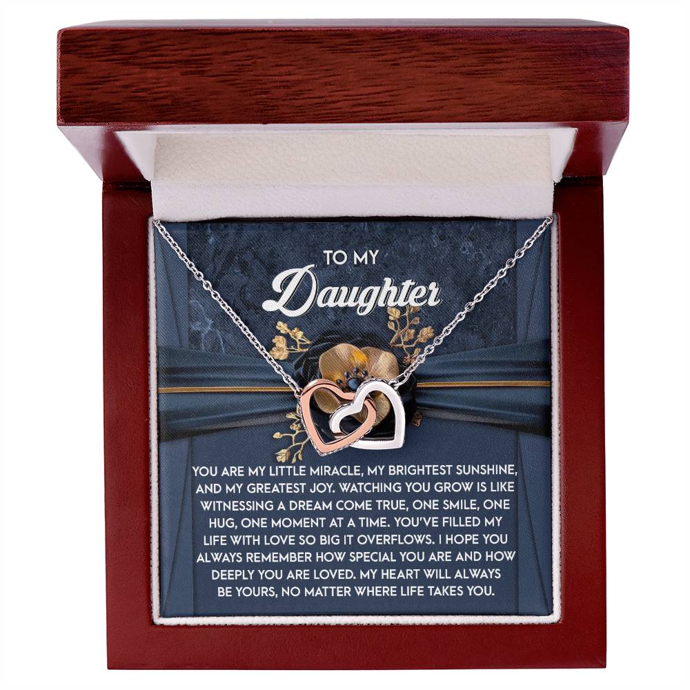 The Daughter-You Are Loved - Interlocking Hearts Necklace features a heart-shaped pendant with cubic zirconia crystals and a rose gold finish, presented in a jewelry box with a heartfelt message expressing love and pride to your daughter.