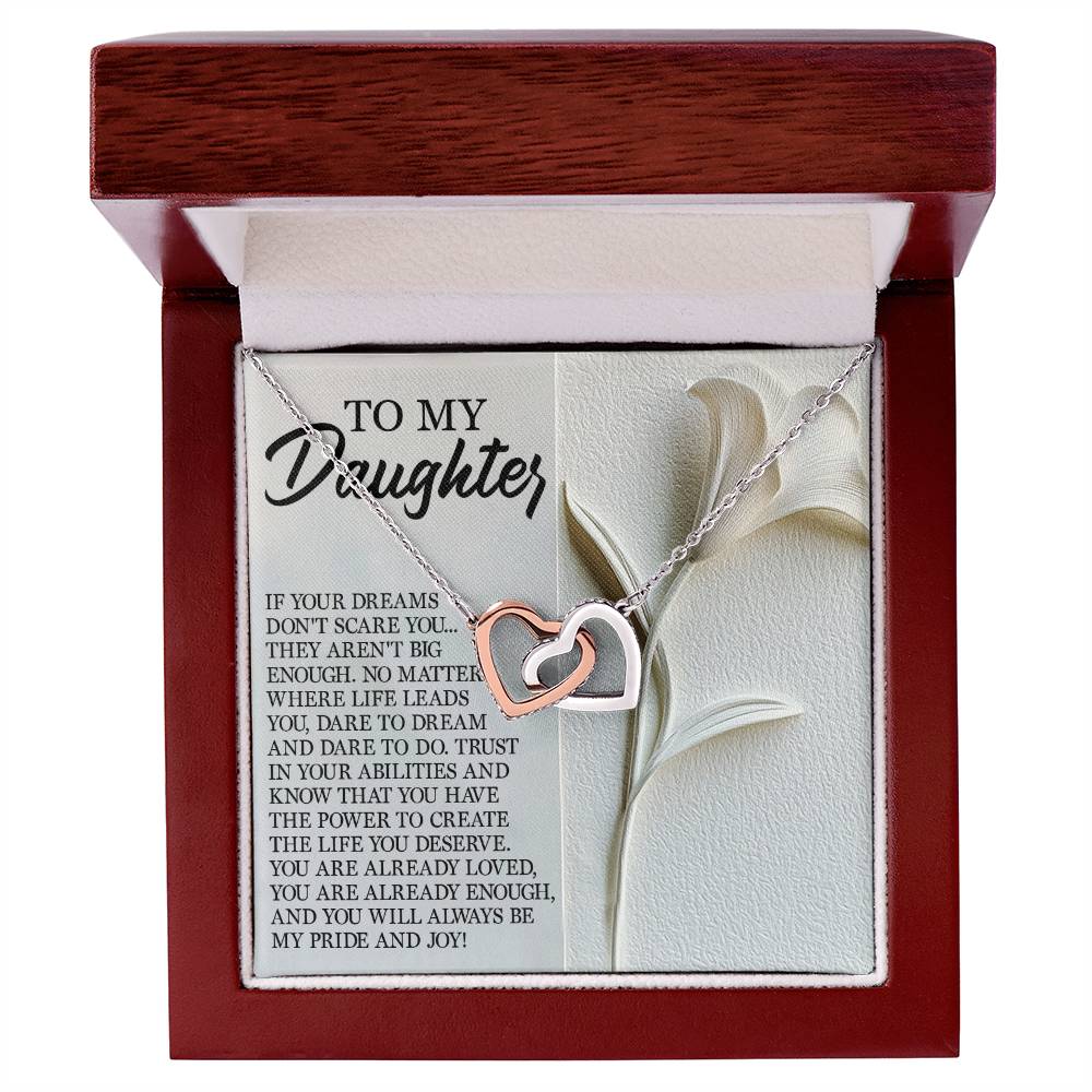 The Daughter-Dare Dream Interlocking Hearts Necklace, adorned with cubic zirconia, is paired with a jewelry box featuring a heartfelt "To my daughter" message and a floral illustration, exuding elegance and love.