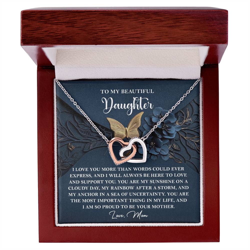 The product "Daughter-In My Life - Interlocking Hearts Necklace" includes a rose gold finished pendant with cubic zirconia crystals in a wooden gift box. The lid displays "To My Beautiful Daughter" along with a heartfelt message from mom.