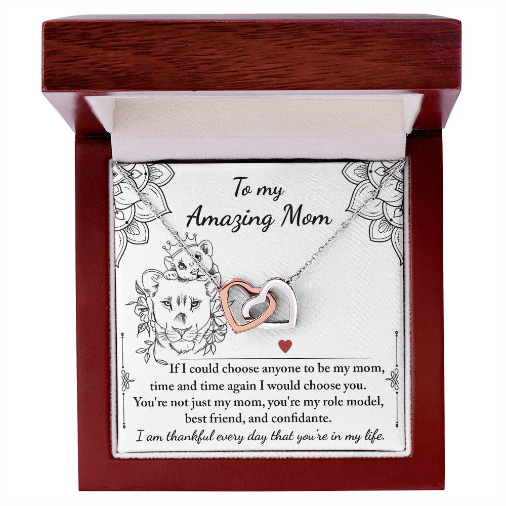 The "To Mom, Be My Mom - Interlocking Hearts Necklace," adorned with cubic zirconia, is packaged in a box showcasing a "my amazing mom" message and a decorative lion illustration, perfectly symbolizing love and admiration.