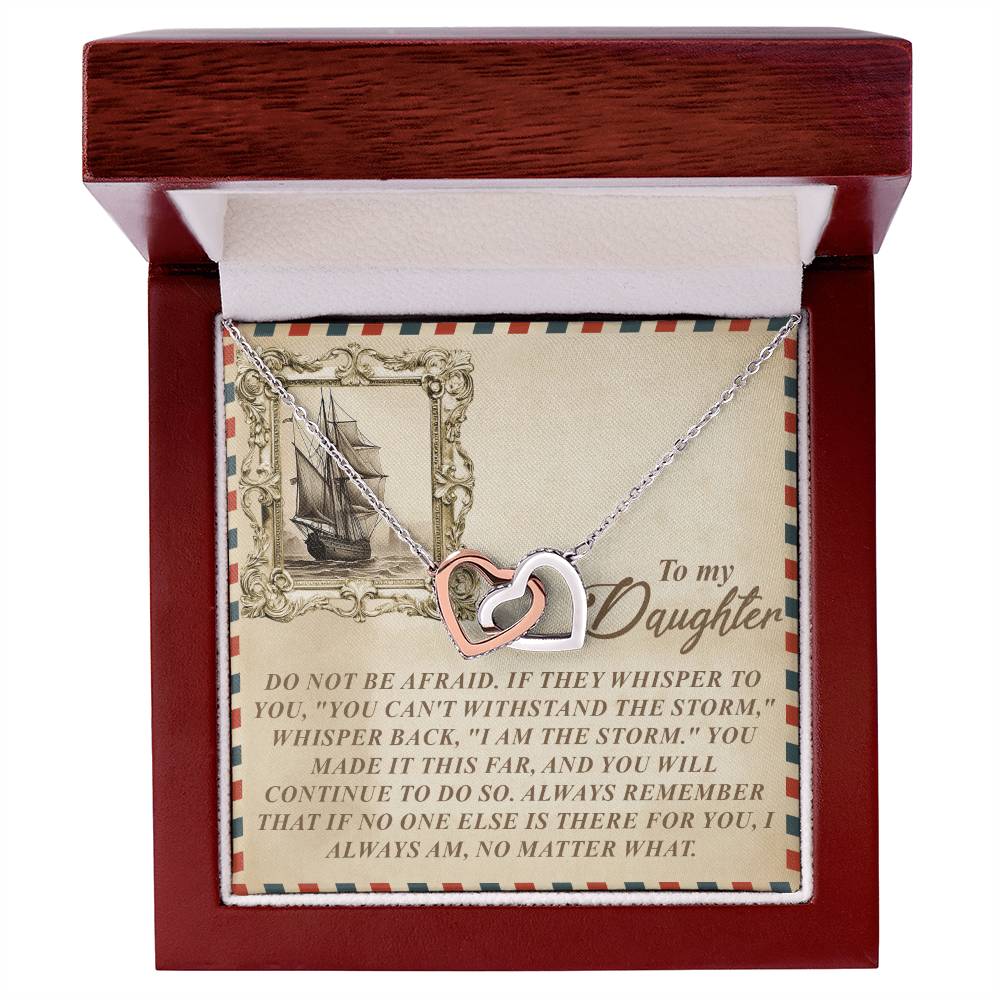 The Daughter-Withstand Storm Interlocking Hearts Necklace, embellished with cubic zirconia crystals, comes in a wooden box. A card accompanies it, inspiring your daughter with a motivational message about her strength and identity, comparing her resilience to enduring the fiercest storm.