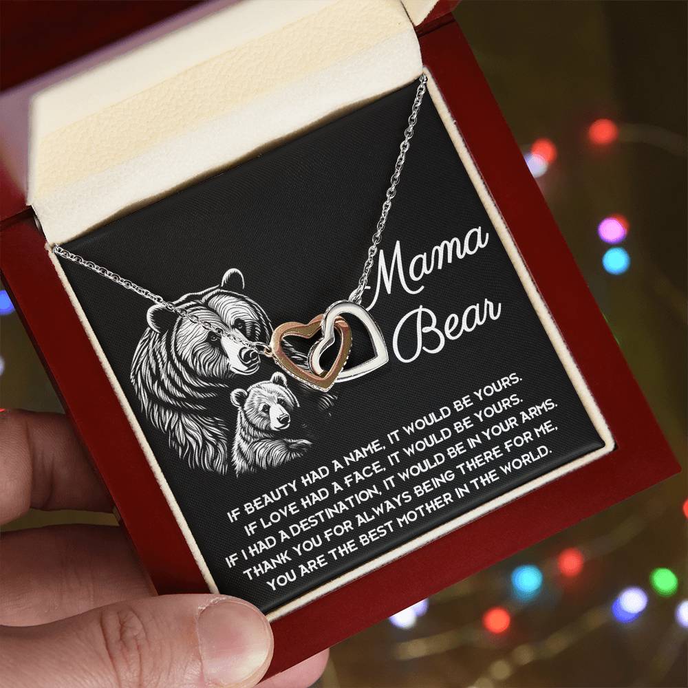 The "To Mom, In Your Arms - Interlocking Hearts Necklace" features cubic zirconia crystals in a "Mama Bear" box with bear illustrations and a heartfelt message, making it the perfect personalized gift for a cherished mother figure.