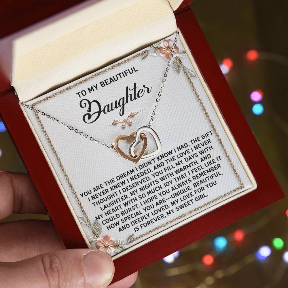 The Daughter-My Sweet Girl Interlocking Hearts Necklace, adorned with cubic zirconia crystals and a rose gold finish, comes in an open box featuring an engraved message of love and appreciation to a daughter.