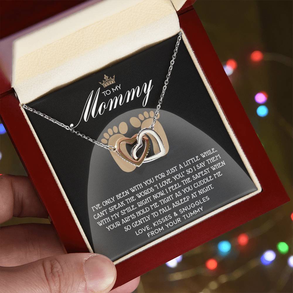 The open jewelry box reveals a stunning Interlocking Hearts Necklace, elegantly finished in rose gold. It comes with an inscription card that reads "To My Mommy" and is adorned with dazzling cubic zirconia crystals, making it a brilliant gift for mama-to-be.